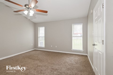 a bedroom with a ceiling fan and a white door