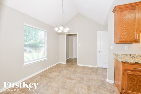 A kitchen with wooden cabinets and a granite countertop.