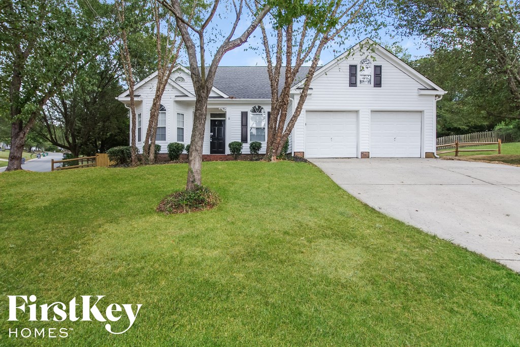 a white house with a driveway and a lawn
