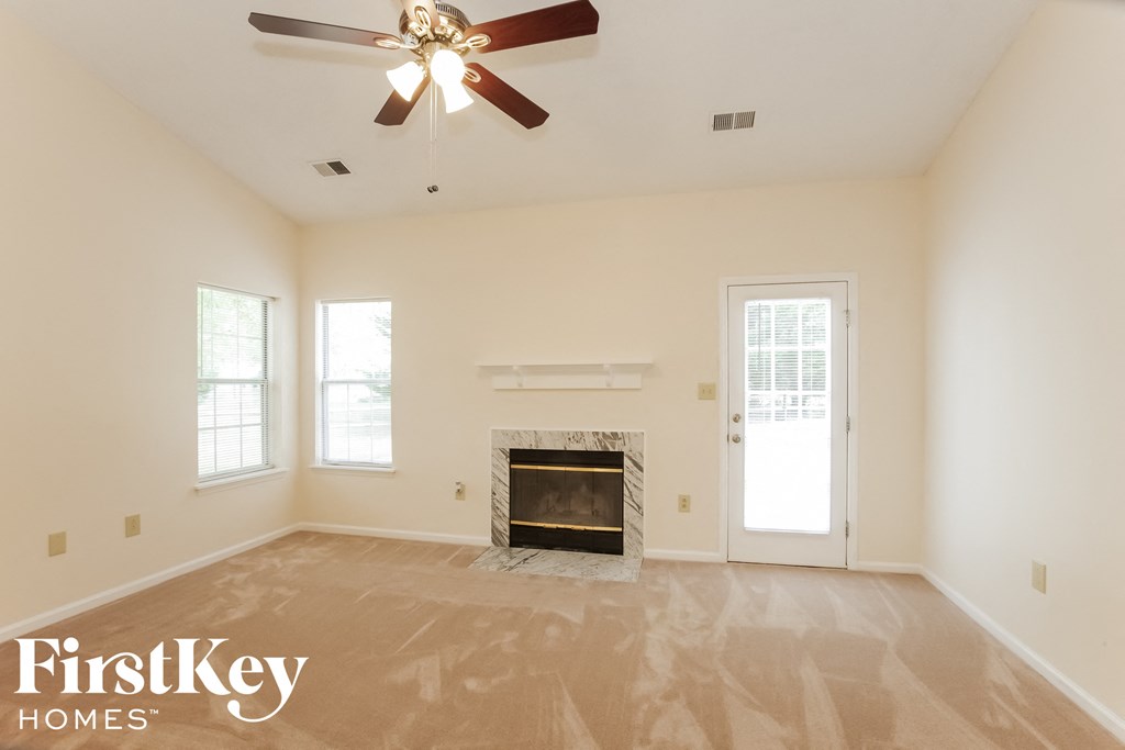 a living room with a fireplace and a ceiling fan