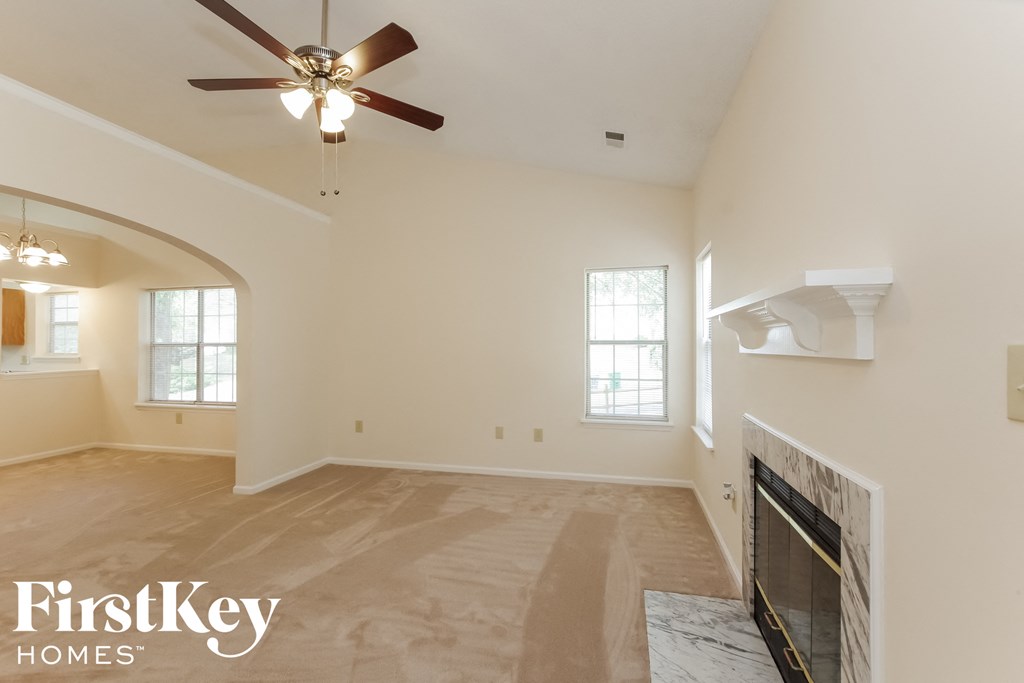 a living room with a fireplace and a ceiling fan