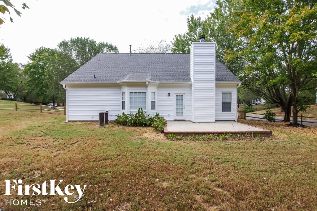 a small white house with a porch and a grassy yard