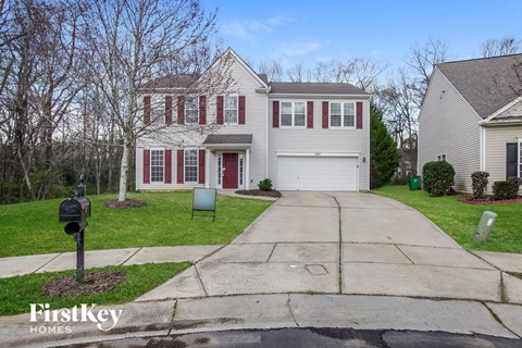 A house with a red door and a mailbox in front.