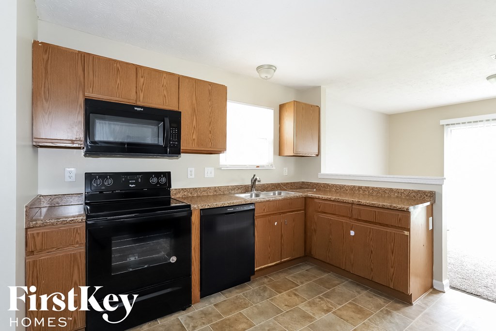 a kitchen with black appliances and wooden cabinets