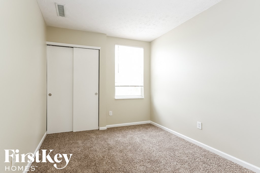 a bedroom with a closet and a window