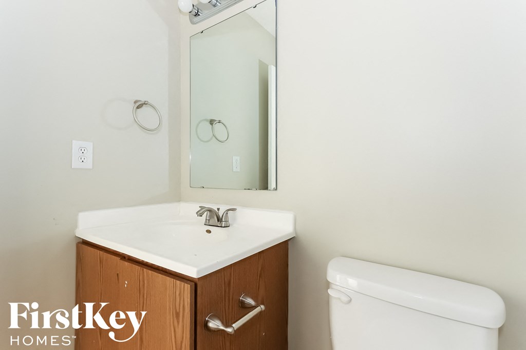 a bathroom with a sink toilet and a mirror