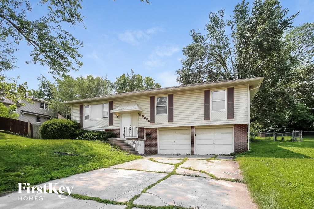 a white and brown house with a driveway and a garage door
