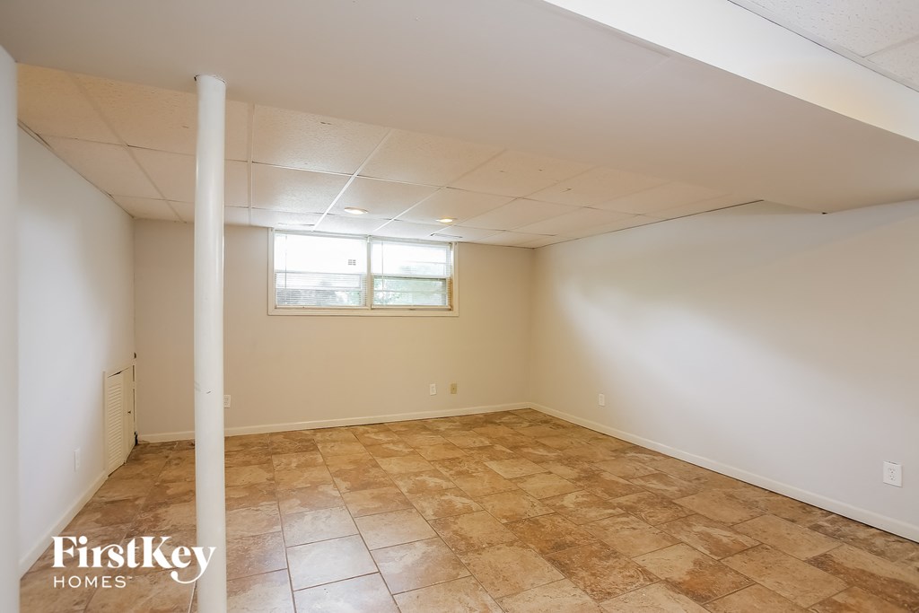 the living room of a home with a tiled floor and a window