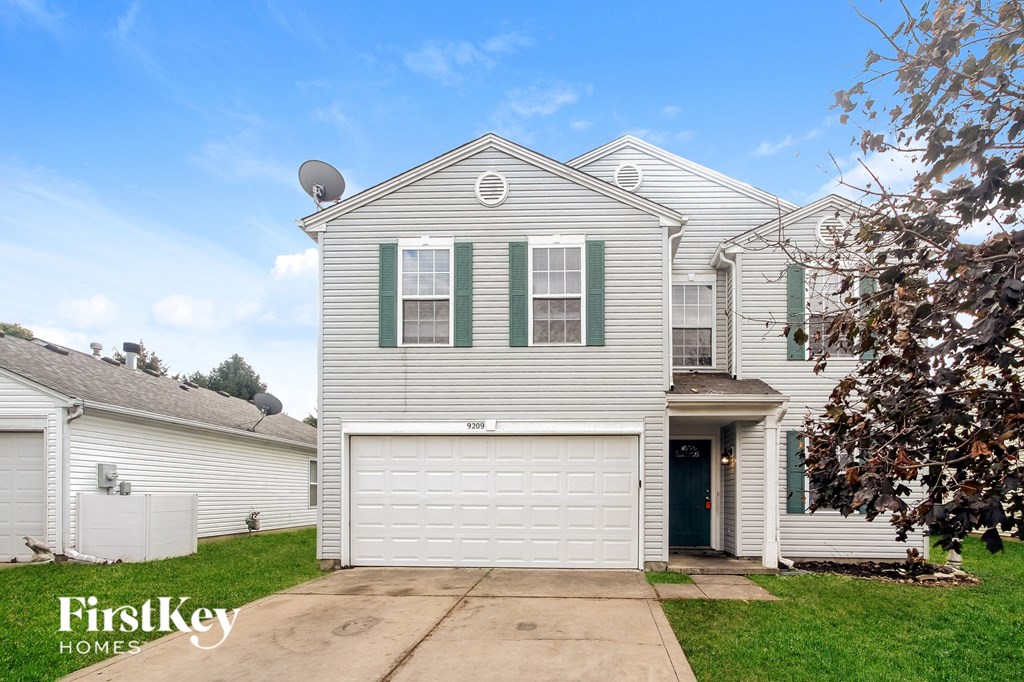 a white house with green shutters and a white garage door