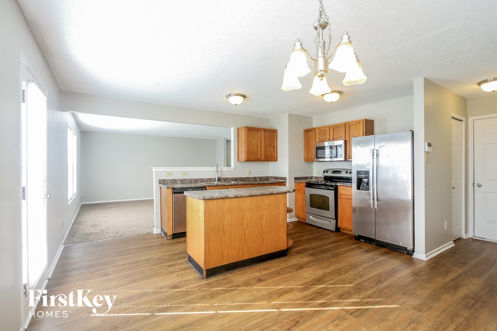 a kitchen with wood floors and stainless steel appliances