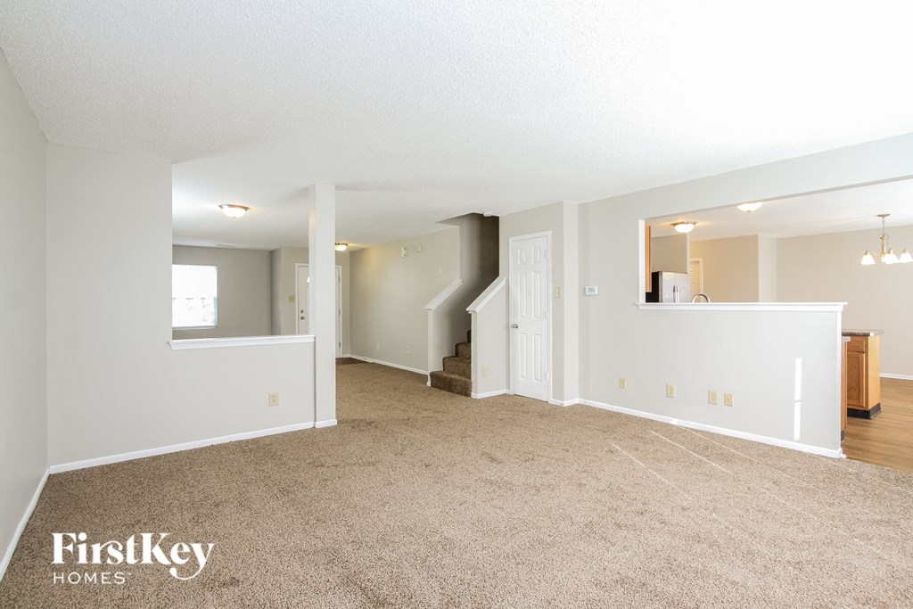 the living room and dining room with the kitchen in the background