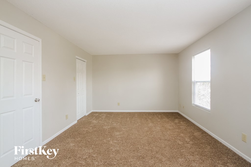 a bedroom with a carpeted floor and a white door