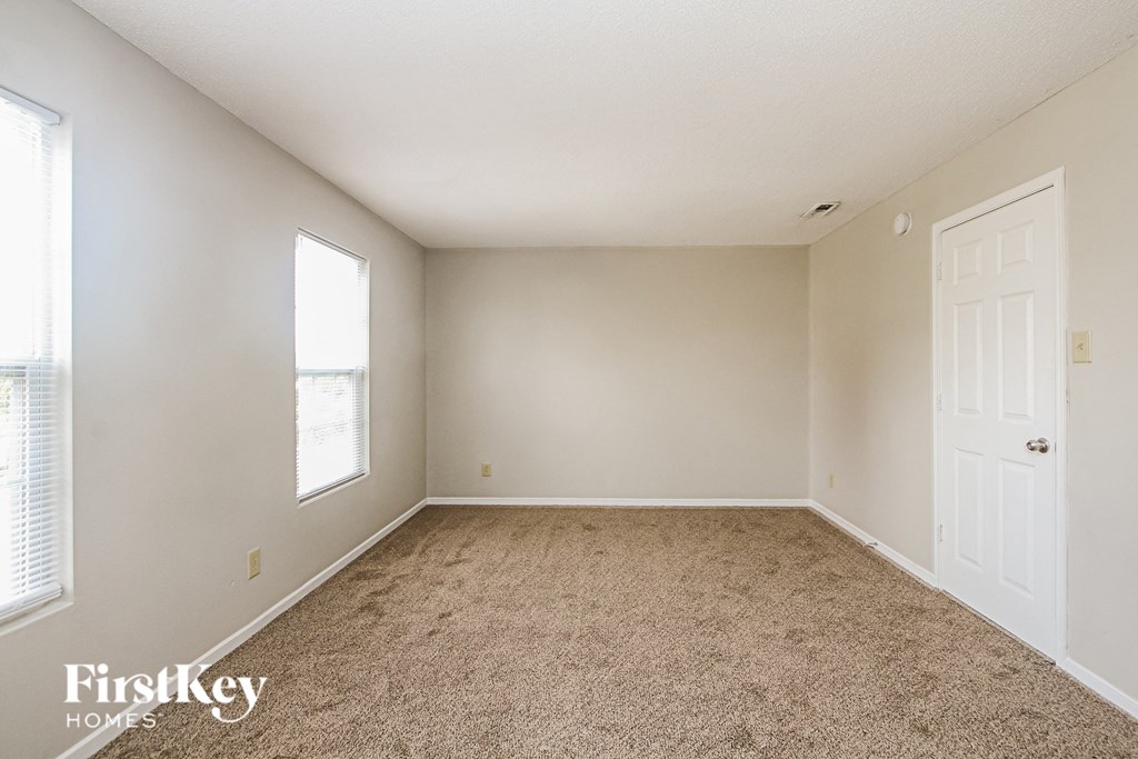 an empty room with carpet and a white door