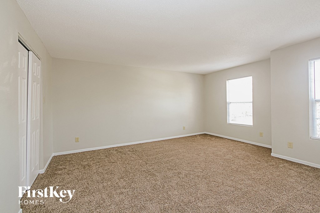 a spacious living room with carpeting and a window