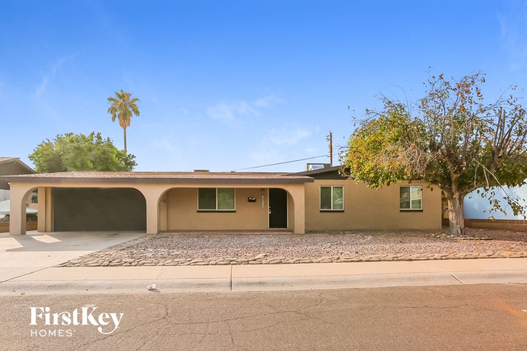 the front of a house with a palm tree and a sidewalk
