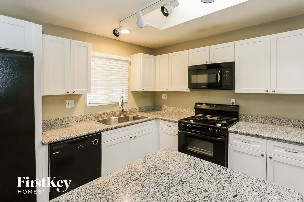 a kitchen with granite counter tops and black appliances