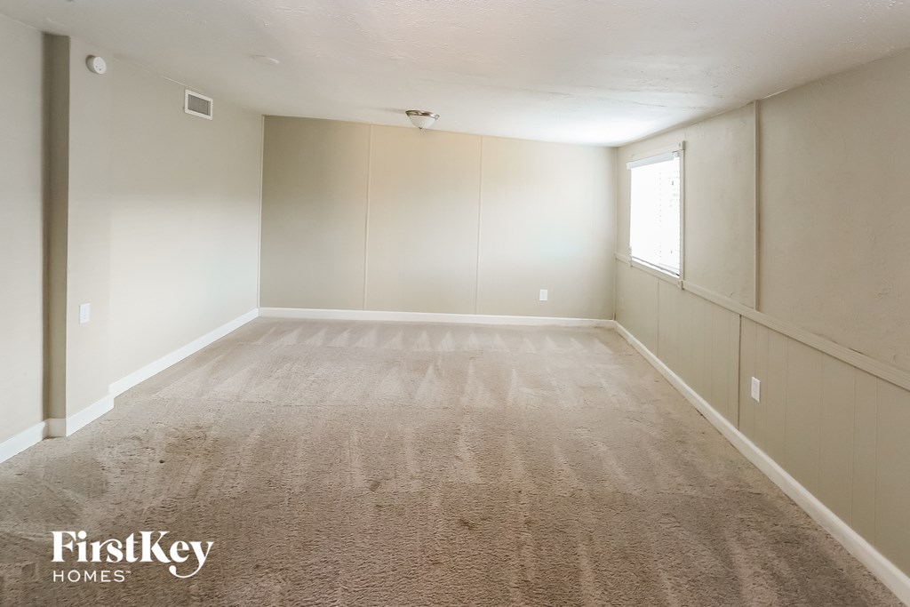 a empty room with carpet and a window