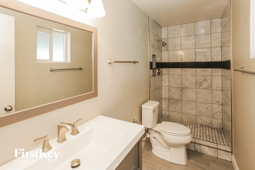 a bathroom with a toilet and a sink and a shower