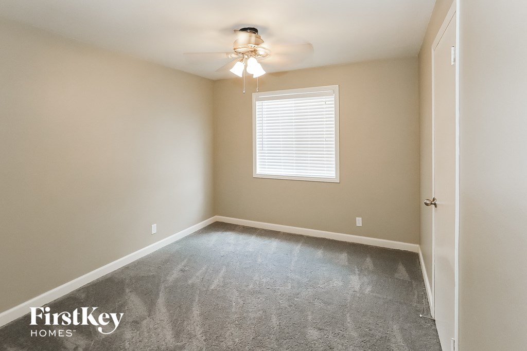a bedroom with a carpeted floor and a ceiling fan
