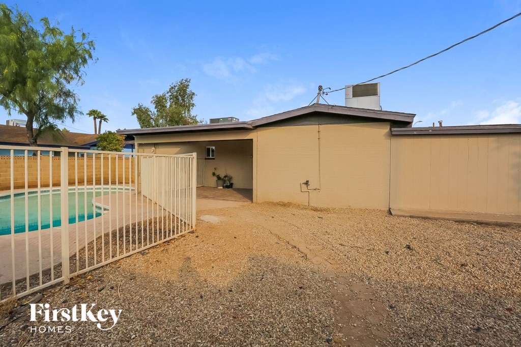 the backyard of a home with a pool and a fence