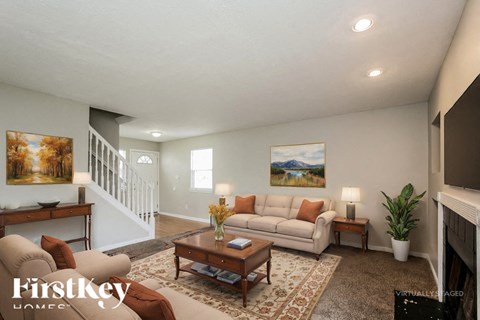 A living room with a couch, coffee table, and a painting on the wall.