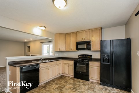A kitchen with black appliances and wooden cabinets.