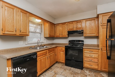 A kitchen with wooden cabinets and black appliances.