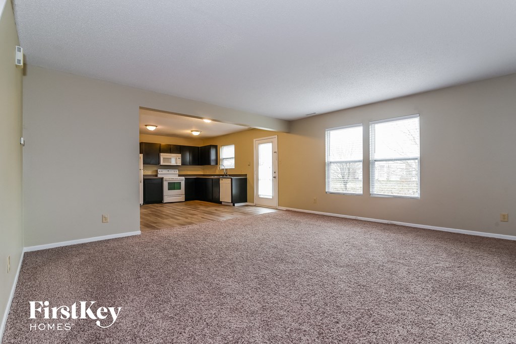 the living room and kitchen of an empty house