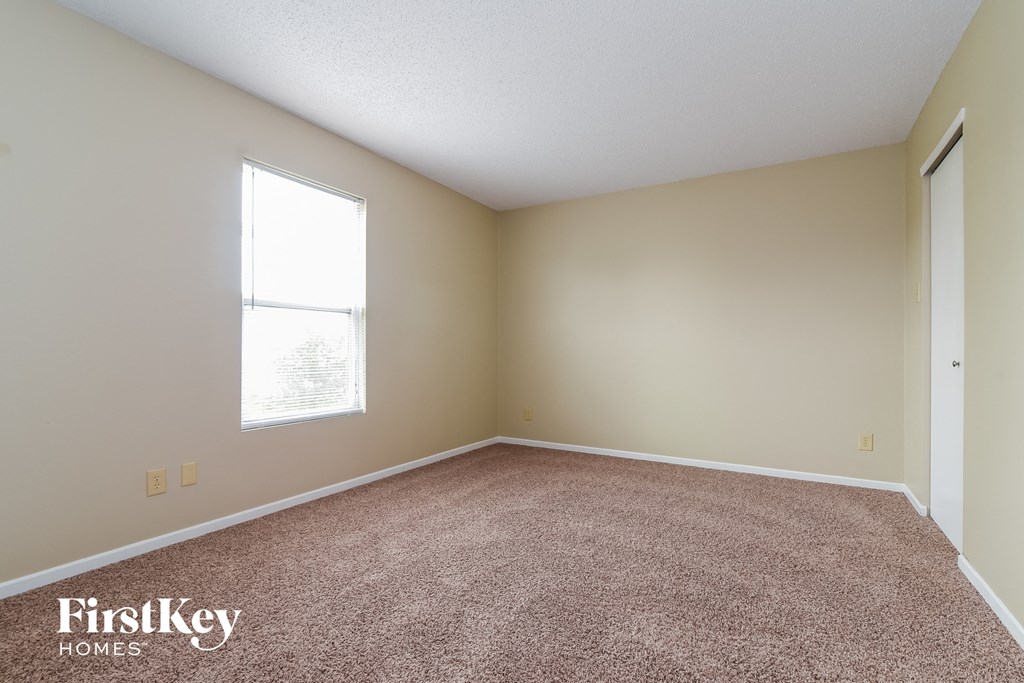 an empty room with carpet and a window