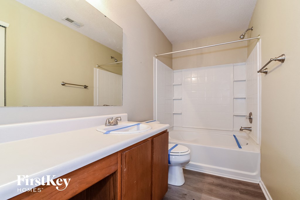 a bathroom with a white tub and a sink and a toilet