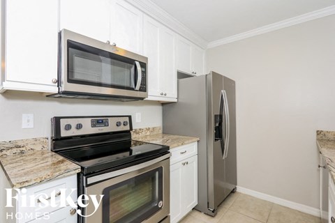 a kitchen with stainless steel appliances and white cabinets