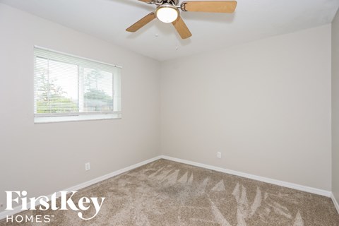 a bedroom with a ceiling fan and a window