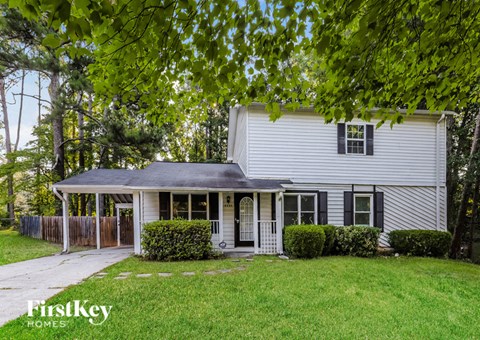a white house with a yard and a porch