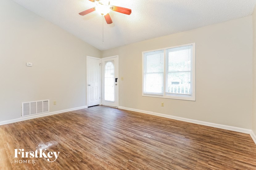 a living room with a wood floor and a ceiling fan