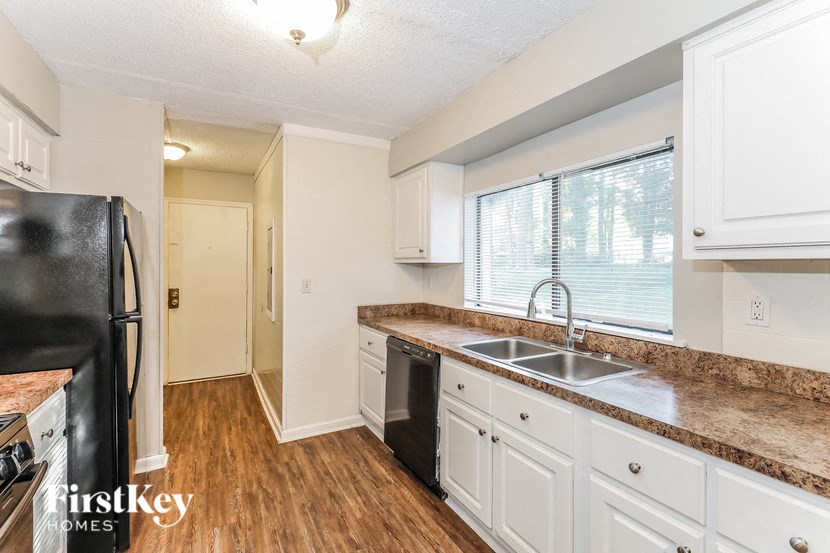 a kitchen with white cabinets and a sink and a refrigerator
