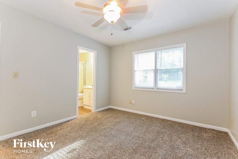 an empty room with a ceiling fan and a window