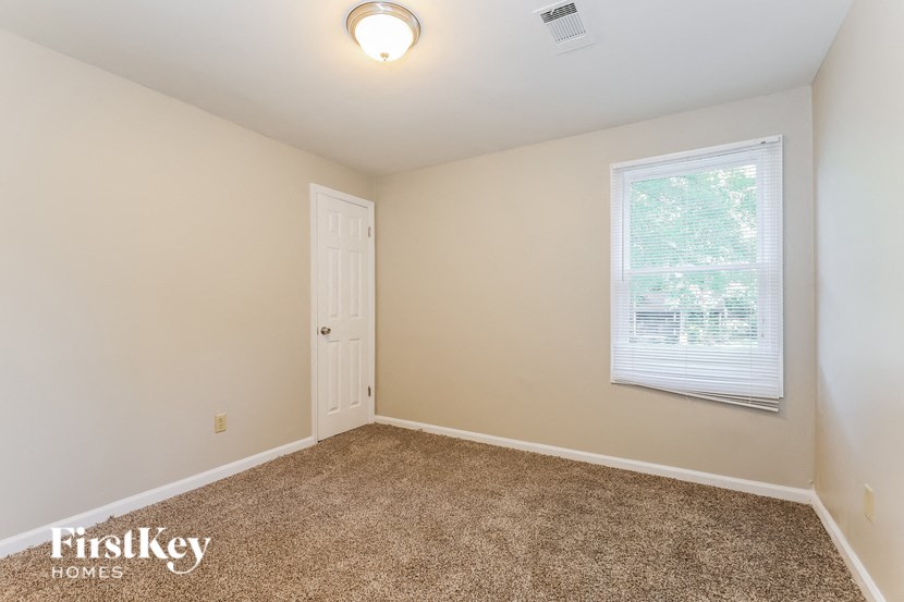 a room with carpet and a window and a door