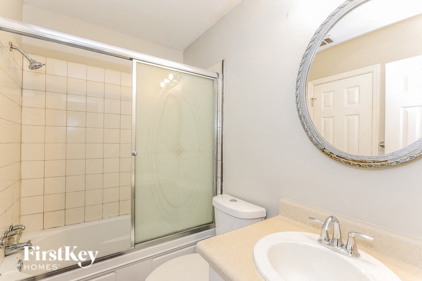 a bathroom with a sink and a shower and a mirror