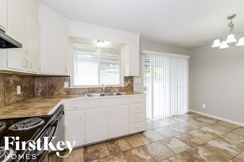 A kitchen with a tiled floor and a stove top oven.