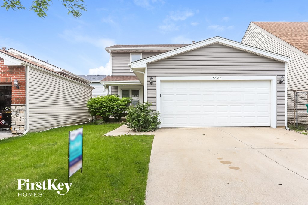 A house with a garage door numbered 9216 is for sale.
