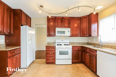A kitchen with brown cabinets and a white stove top oven.