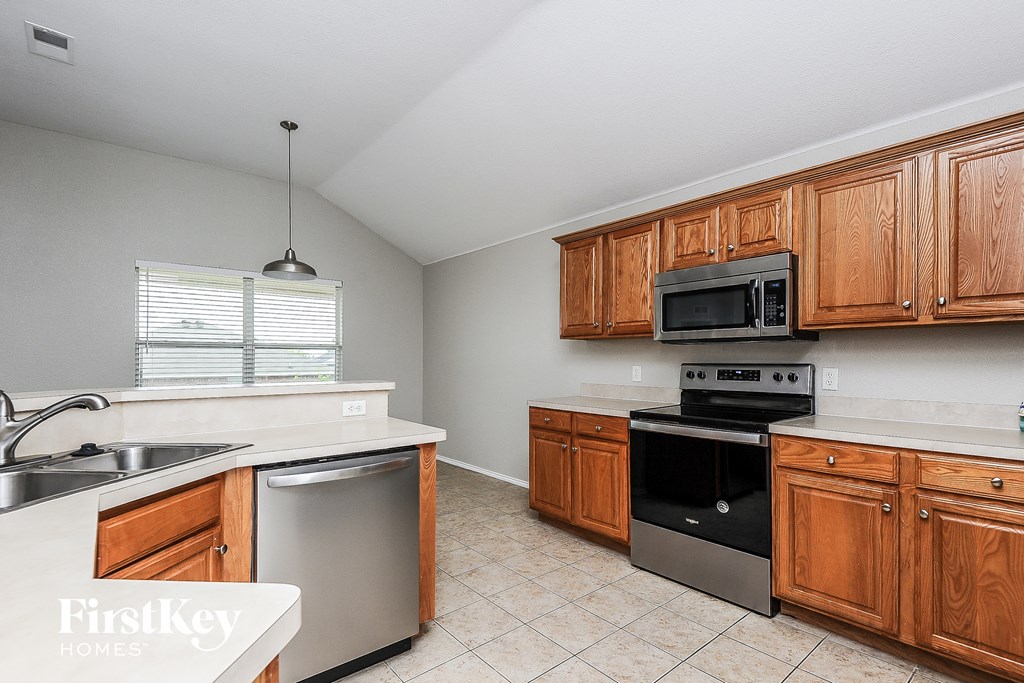 a kitchen with wooden cabinets and stainless steel appliances