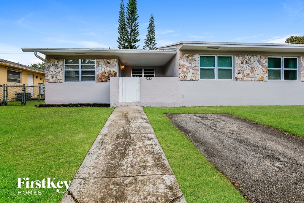 a white house with green grass and a driveway