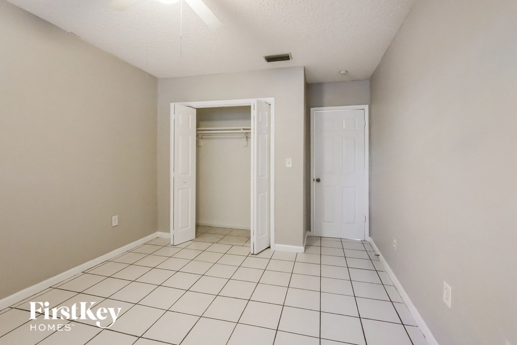 an empty room with a tiled floor and a closet