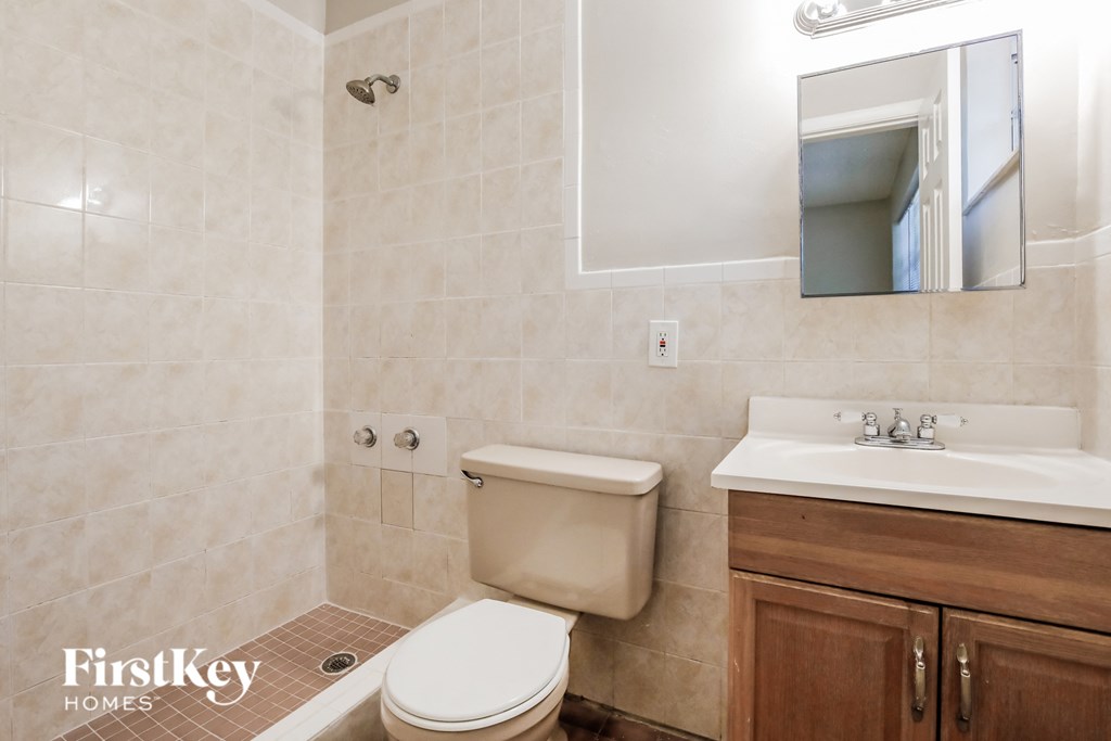 a bathroom with a toilet sink and a mirror