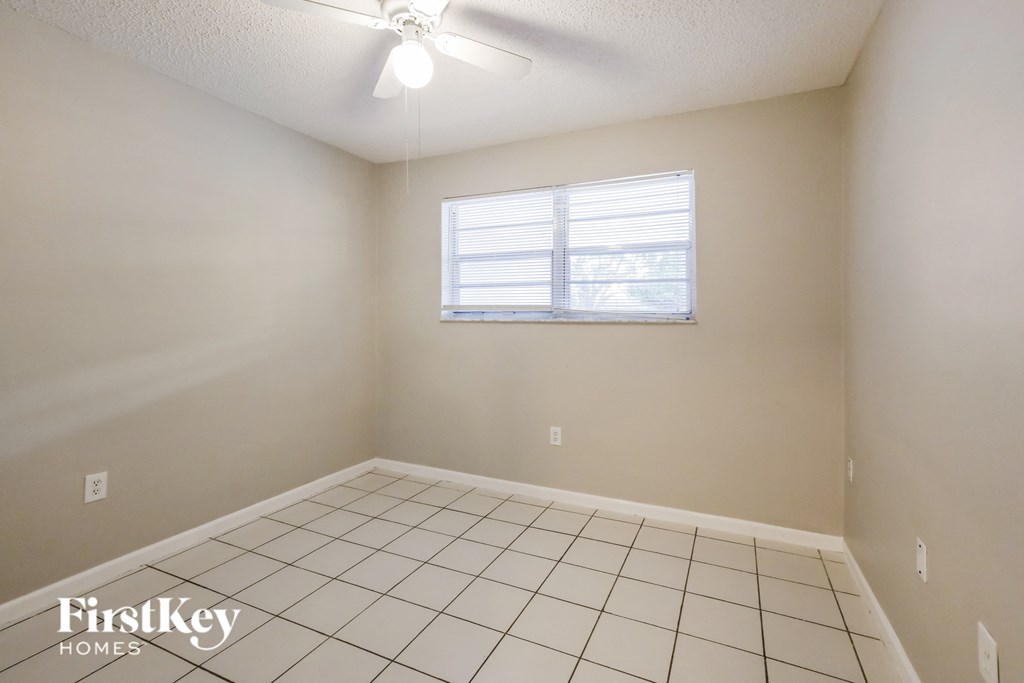 a room with a white tiled floor and a window