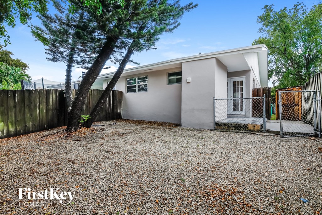 a small white house with a yard and a fence