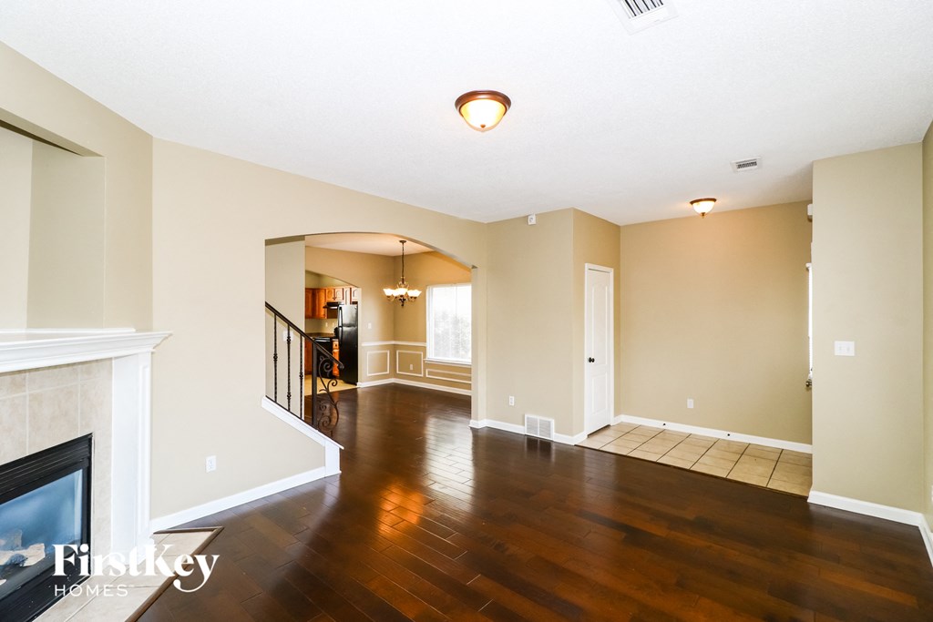 an empty living room with hard wood floors and a fireplace
