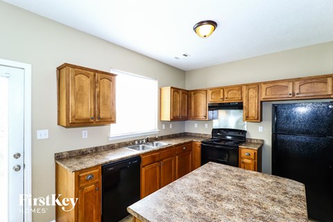 a kitchen with wooden cabinets and black appliances and granite counter tops