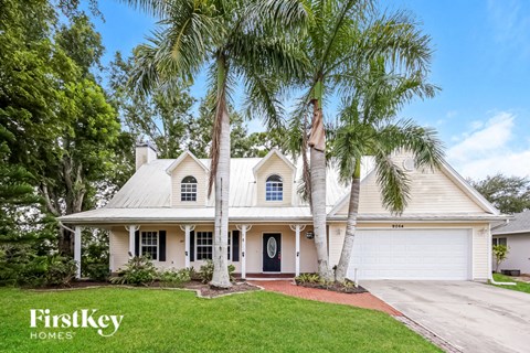a white house with palm trees in front of it